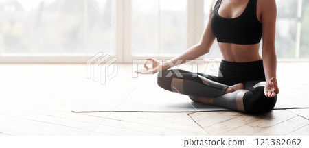 Cropped of yoga girl sitting in lotus pose and meditating at home, copy space Cropped of yoga girl sitting in lotus pose and meditating at home, copy space 121382062