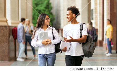 College friends walking in campus and talking, having break after classes 121382068