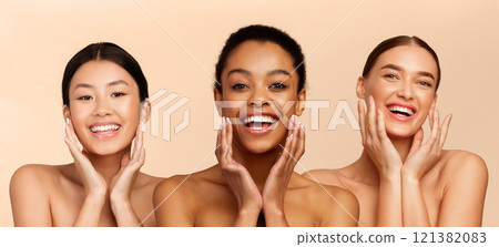 Facial Skincare. Three Beautiful Diverse Girls Posing Touching Face Perfect Skin Smiling At Camera Standing Over White Studio Background. Panorama 121382083
