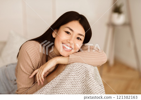 Happy Asian Girl Relaxing In Living Room, Looking At Camera 121382163