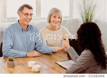 Realtor. Real estate agent giving keys to apartment to elderly couple, new owners buying property business Realtor. Real estate agent giving keys to apartment to elderly couple, new owners buying property business 121382448