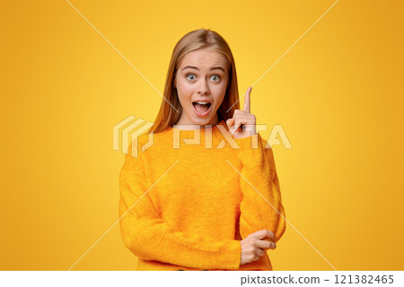 Eureka. Emotional teen girl having idea, pointing finger up, found problem solution, orange studio background Eureka. Emotional teen girl having idea, pointing finger up, found problem solution, orange studio background 121382465