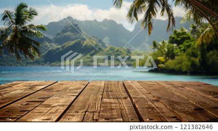 A wooden deck overlooking a tropical lagoon with lush green mountains and palm trees in the background. 121382646