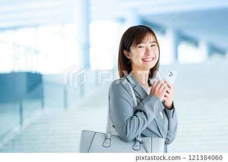 A woman in a suit going to work, an office lady walking through a bright lobby, a working office lady 121384060