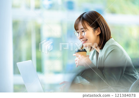 Woman working on a computer Woman working in a cafe 121384078