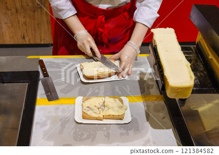 delicious wheel of raclette cheese has been heated on cutting edge. delicious wheel of raclette cheese has been heated on cutting edge. 121384582