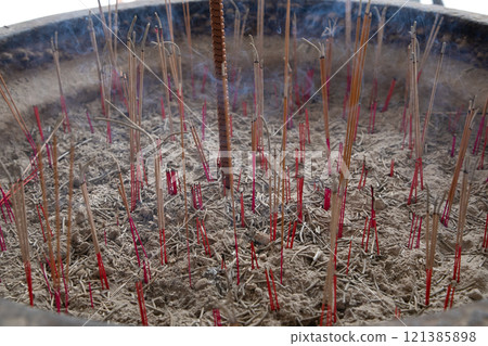 Joss sticks in smoking bowl are smoking and smelling. 121385898