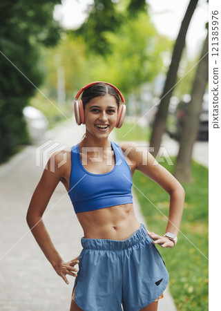 An Energetic and Inspiring Young Woman Dressed in Stylish Sportswear Enjoying Fitness Outdoors 121385976