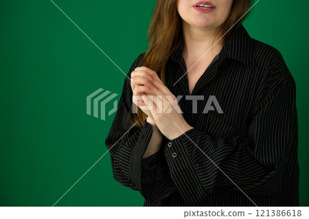Woman with clasped hands praying on beige background 121386618