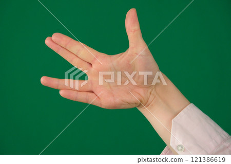 Vulcan greeting, womans hand, isolated on green 121386619
