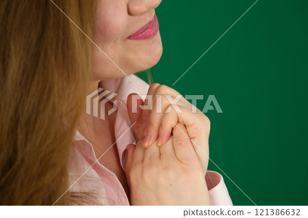 Portrait of happy millennial female volunteer holding folded hands on chest, looking at camera. Kind smiling young woman feeling thankful, showing appreciation, gratitude believe charity concept. Portrait of happy millennial female volunteer holding folded hands on chest, looking at camera. Kind smiling young woman feeling thankful, showing appreciation, gratitude believe charity concept. 121386632