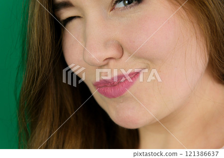 Skincare and beauty. Close up of smiling young woman winking at camera, touching shiny healthy skin, nourished face after tea tree and lemon facial serum and moisturizer,background. Skincare and beauty. Close up of smiling young woman winking at camera, touching shiny healthy skin, nourished face after tea tree and lemon facial serum and moisturizer,background. 121386637