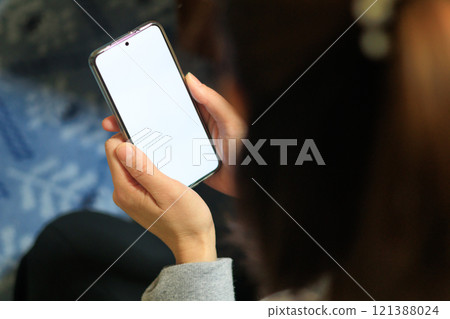 A woman operating a smartphone A woman operating a smartphone 121388024