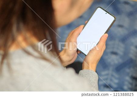 A woman operating a smartphone A woman operating a smartphone 121388025