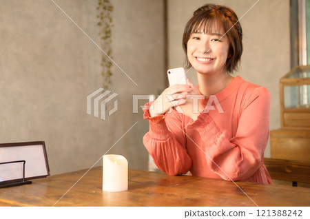 一位女士在咖啡館使用智慧型手機 121388242