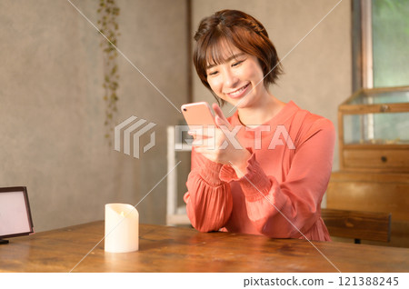 A woman using a smartphone in a cafe 121388245