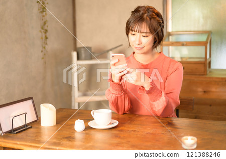 A woman using a smartphone in a cafe 121388246