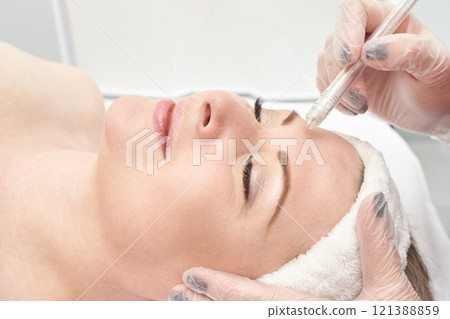 Caucasian female adult receiving eyebrow microblading treatment in beauty salon 121388859