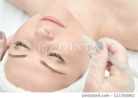 Caucasian female receiving skincare treatment with microdermabrasion for smooth Caucasian female receiving skincare treatment with microdermabrasion for smooth 121388862