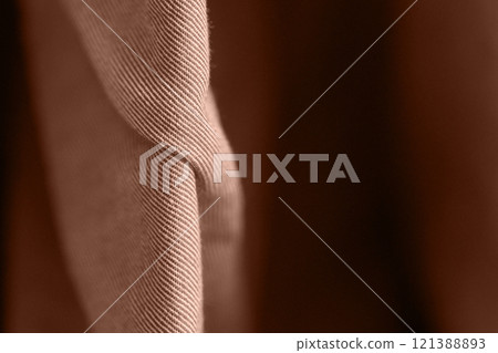 Close up of brown fabric with detailed texture and soft folds in subtle light Close up of brown fabric with detailed texture and soft folds in subtle light 121388893