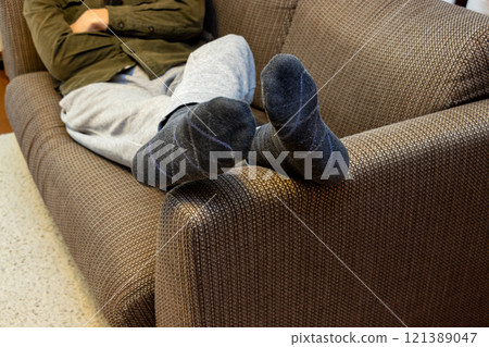 Man lying on sofa 121389047