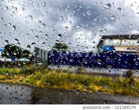 Raindrops covering a window create a picturesque scene Raindrops covering a window create a picturesque scene 121389174