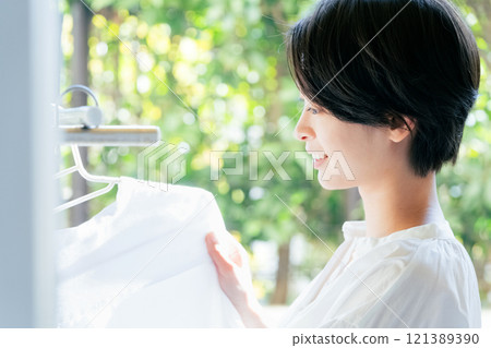A woman hanging up the laundry 121389390