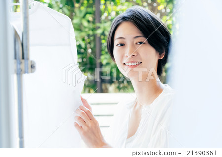 A woman hanging up the laundry 121390361