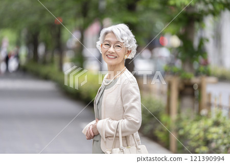 Senior woman looking at camera and smiling Senior woman looking at camera and smiling 121390994
