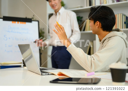 Asian student man asking a question while tutor explaining something on the whiteboard 121391022