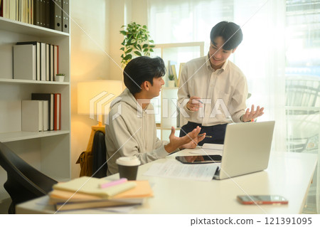 Smiling tutor guides a student through a lesson during a home tutoring session 121391095