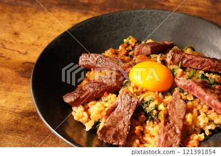 烤牛裙牛排和蛋黃放在拌飯式炒飯上 121391854