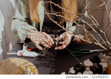 Unrecognizable woman creating Easter holiday decoration from egg shell. Diy do it yourself step by step instruction. Crafting preparation Unrecognizable woman creating Easter holiday decoration from egg shell. Diy do it yourself step by step instruction. Crafting preparation 121392013