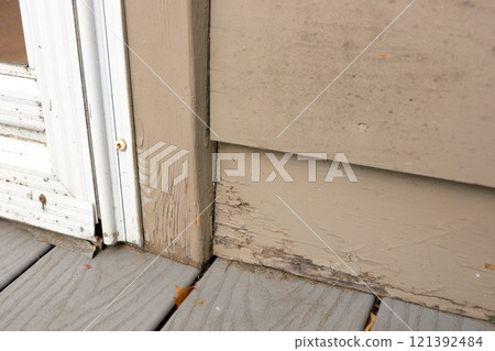 Wood Siding on House shows peeling and cracked painting and early signs of decay and rot Wood Siding on House shows peeling and cracked painting and early signs of decay and rot 121392484