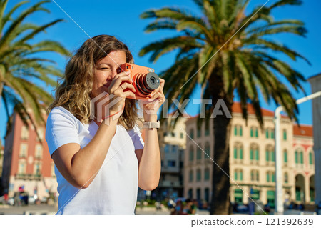 Young Woman Taking Photos in Coastal Town 121392639
