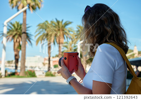 Young Woman Taking Photos in Coastal Town 121392643