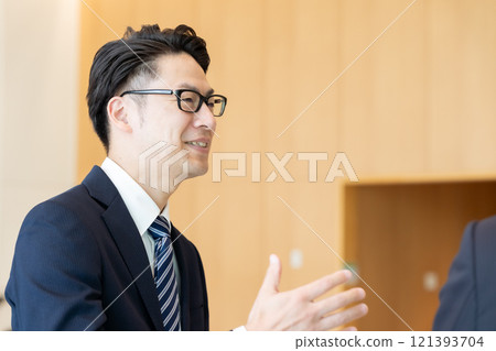 A boss and a subordinate having a conversation in the office lobby A boss and a subordinate having a conversation in the office lobby 121393704