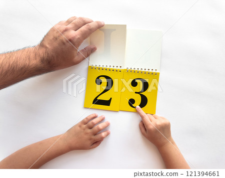 Learning numbers together. Adult and child hands interacting with calendar pages Learning numbers together. Adult and child hands interacting with calendar pages 121394661