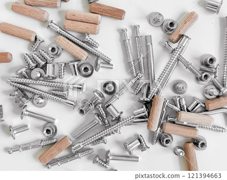 Assorted hardware pieces. Screws, dowels, and fasteners on white background 121394663