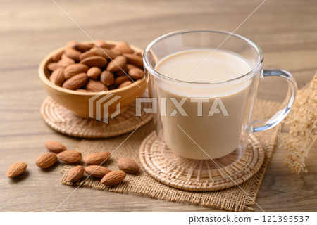 Almond milk in cup glass on wooden table, Alternative milk made from plant, non dairy Almond milk in cup glass on wooden table, Alternative milk made from plant, non dairy 121395537