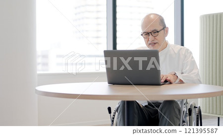 Elderly person in a wheelchair confused by a computer 121395587
