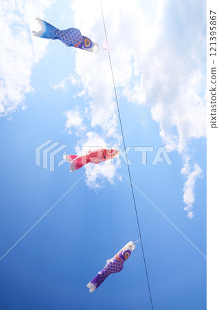 Spring scenery with carp streamers swimming in the blue sky Spring scenery with carp streamers swimming in the blue sky 121395867