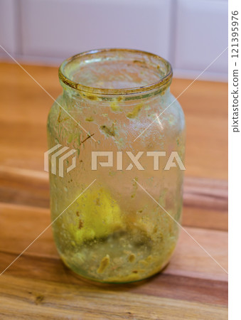 Dirty glass Jar with Leftover Food on wood table in kitchen . High quality photo 121395976