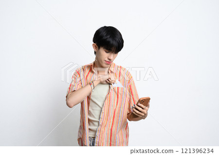 Smiling man holding smartphone and taking out a credit card from his pocket 121396234