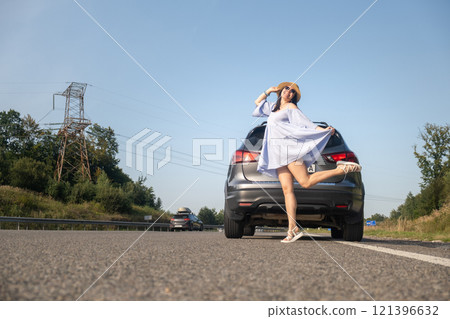 Cheerful Woman Posing by SUV on Sunny Day 121396632