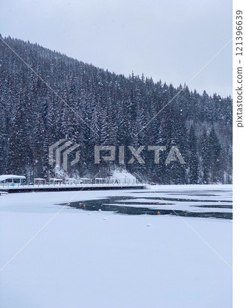 Snow-Covered Lake and Pine Forest in Winter 121396639