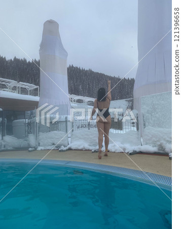 Winter Poolside Relaxation in Snowy Landscape 121396658
