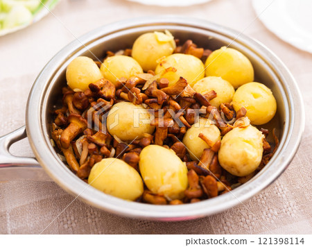Delicious fried chanterelles with new potatoes in a frying pan 121398114