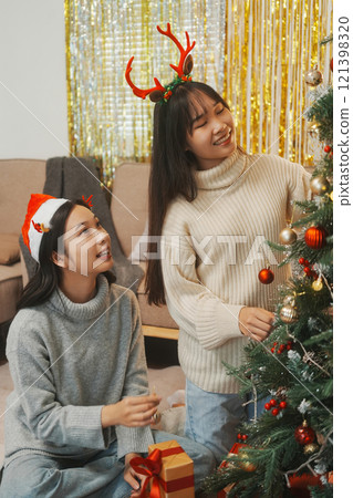 Two friends decorated Christmas tree at home. 121398320