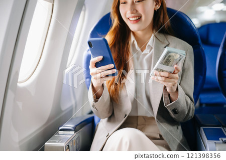 Young Asian executive excels in first class, multitasking with digital tablet, laptop and smartphone. for finance, travel, and lifestyle 121398356